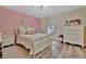 Charming bedroom featuring floral bedding, hardwood floors, and natural light from the window at 9136 Warm Springs Cir, Parrish, FL 34219