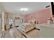 Charming bedroom with a pink accent wall, a light wood floor, and bright natural light at 9136 Warm Springs Cir, Parrish, FL 34219