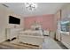Inviting bedroom with floral bedding, hardwood floors, and pink accent wall at 9136 Warm Springs Cir, Parrish, FL 34219