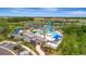 Aerial view of a luxurious community pool area with a water slide, cabanas, and palm trees at 9136 Warm Springs Cir, Parrish, FL 34219