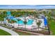 Overhead shot of a fancy community pool featuring lounge chairs, umbrellas, palm trees, and a waterslide at 9136 Warm Springs Cir, Parrish, FL 34219
