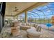 A cozy covered patio features comfortable seating and ceiling fans overlooking the pool and scenic backyard at 9136 Warm Springs Cir, Parrish, FL 34219
