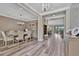 Elegant dining room with chandelier, decorative china cabinet, hardwood floors and views of adjacent living areas at 9136 Warm Springs Cir, Parrish, FL 34219