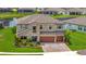 Stunning two-story home boasts a lush green lawn, a charming front garden, and a serene pond view at 9136 Warm Springs Cir, Parrish, FL 34219