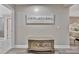 Hallway featuring decorative furnishing and artwork, with a glimpse into a bedroom and bathroom beyond at 9136 Warm Springs Cir, Parrish, FL 34219
