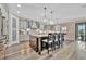 Modern kitchen features an island with seating, granite countertops and stainless appliances at 9136 Warm Springs Cir, Parrish, FL 34219
