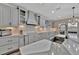 Gourmet kitchen with a large island, stainless steel sink, and stylish gray cabinets at 9136 Warm Springs Cir, Parrish, FL 34219