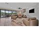 Cozy living room with sleek hardwood flooring, dark trim windows, and an inviting seating arrangement at 9136 Warm Springs Cir, Parrish, FL 34219