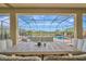 Inviting covered patio with wicker dining set overlooking the screened-in pool and the beautiful backyard at 9136 Warm Springs Cir, Parrish, FL 34219