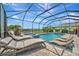 Relaxing backyard pool with lounge chairs, scenic views, and a screened-in enclosure with lake view at 9136 Warm Springs Cir, Parrish, FL 34219