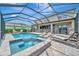 Gorgeous backyard with a large screened pool, spa, and lounge area, perfect for entertaining and relaxation at 9136 Warm Springs Cir, Parrish, FL 34219