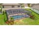 Beautiful backyard with screened pool, lounge chairs, and tropical landscaping, perfect for relaxation at 9136 Warm Springs Cir, Parrish, FL 34219