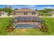 Relaxing screened-in pool area featuring comfortable lounge chairs, lush landscaping, and a spa at 9136 Warm Springs Cir, Parrish, FL 34219
