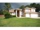 Inviting two-story home featuring a well-manicured lawn, attached two-car garage, and a neutral color palette at 10402 Ashley Oaks Drive, Riverview, FL 33578