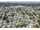 Overhead view of a neighborhood with diverse homes, lush greenery, and distant water views at 12359 82Nd N Ave, Seminole, FL 33772