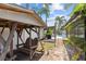 Inviting backyard featuring a swing, outdoor grill setup, stone walkway, and lush tropical landscaping at 12359 82Nd N Ave, Seminole, FL 33772