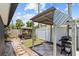 Cozy backyard with a charming swing, outdoor grill area, and a mix of stone and paved pathways at 12359 82Nd N Ave, Seminole, FL 33772