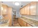 Well-lit kitchen featuring wooden cabinets, granite countertops and tile backsplash, seamlessly connects to the dining area at 12359 82Nd N Ave, Seminole, FL 33772