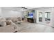 Relaxing living area with a large sectional sofa, wood floors, and glass doors leading to the outdoor patio at 12359 82Nd N Ave, Seminole, FL 33772