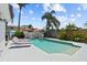 Sparkling swimming pool with lounge chairs, surrounded by a well-maintained backyard and tropical foliage at 12359 82Nd N Ave, Seminole, FL 33772