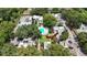 Aerial view highlighting the blue pool and lush greenery, with a red arrow pointing towards the main entrance at 125 Picardy Villa Cir # 100, Brandon, FL 33510