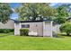 A green lawn and shrubbery surrounds the exterior of the building with white doors and blue trim on a sunny day at 125 Picardy Villa Cir # 100, Brandon, FL 33510