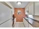 Well-lit kitchen featuring a brick accent wall, white cabinets, and modern appliances at 125 Picardy Villa Cir # 100, Brandon, FL 33510
