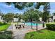 A community swimming pool surrounded by lush trees and picnic tables provides a refreshing escape from the summer heat at 125 Picardy Villa Cir # 100, Brandon, FL 33510