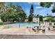 A community swimming pool surrounded by lush trees and picnic tables provides a refreshing escape from the summer heat at 125 Picardy Villa Cir # 100, Brandon, FL 33510