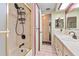 Bright bathroom featuring a tub with shower, white vanity, and doorway leading to another room at 12501 Ulmerton Rd # 110, Largo, FL 33774