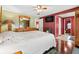 Comfortable bedroom with wood floors, paneled accent wall and en suite bathroom at 12501 Ulmerton Rd # 110, Largo, FL 33774