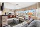 Bright living room with large windows, wood-look walls, comfortable seating, and a functional workspace at 12501 Ulmerton Rd # 110, Largo, FL 33774