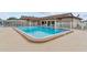 Outdoor community pool surrounded by a patio, secured with a fence, and furnished with seating at 12501 Ulmerton Rd # 110, Largo, FL 33774