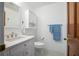 Bathroom featuring white vanity, toilet, and accessories in front of dark wood door at 13296 88Th N Ave, Seminole, FL 33776