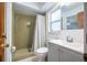 Bathroom with a tiled shower, window, mirror, and a gray vanity at 13296 88Th N Ave, Seminole, FL 33776