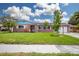 Charming brick home with a well-manicured lawn, vibrant foliage, and a two-car garage at 13296 88Th N Ave, Seminole, FL 33776