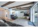 Living room with wooden beam ceiling, a view to the kitchen, and light-colored wood floors at 13296 88Th N Ave, Seminole, FL 33776