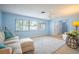 Bright living room with light blue walls, wood floors, and views to the front yard at 13296 88Th N Ave, Seminole, FL 33776