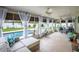 Sunroom with travertine tile, ceiling fans, and curtains that open to the pool and backyard at 13296 88Th N Ave, Seminole, FL 33776