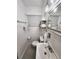 Compact bathroom with a white sink, toilet, and storage shelves at 1335 Waikiki Way, Tampa, FL 33619