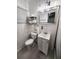 Compact bathroom with white fixtures and storage shelves at 1335 Waikiki Way, Tampa, FL 33619