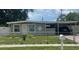 Charming single-story home with a carport, well-maintained lawn, and a white picket fence at 1335 Waikiki Way, Tampa, FL 33619