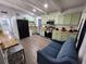 Kitchen featuring sage green cabinets, modern appliances, breakfast bar, and stylish furnishings at 1335 Waikiki Way, Tampa, FL 33619