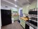 Close-up of the kitchen, showing the stainless appliances, light green cabinets, and countertop space at 1335 Waikiki Way, Tampa, FL 33619