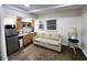 Open living area with wood floors, kitchen, and comfortable seating at 1335 Waikiki Way, Tampa, FL 33619