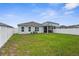 Well-maintained backyard featuring a green lawn, white fence, and screened-in porch at 14532 Whitewater Way, Brooksville, FL 34604