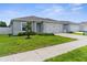 Well-manicured front lawn and a charming gray home with a two-car garage enhance the curb appeal of this property at 14532 Whitewater Way, Brooksville, FL 34604