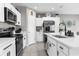 Updated kitchen features stainless appliances, white cabinets, and a breakfast bar island at 14532 Whitewater Way, Brooksville, FL 34604