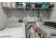 Well-organized laundry room featuring a washer, dryer, shelving, and cleaning supplies at 14532 Whitewater Way, Brooksville, FL 34604