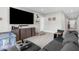 Bright living room offers gray walls, tile flooring, and a cozy gray sectional couch at 14532 Whitewater Way, Brooksville, FL 34604